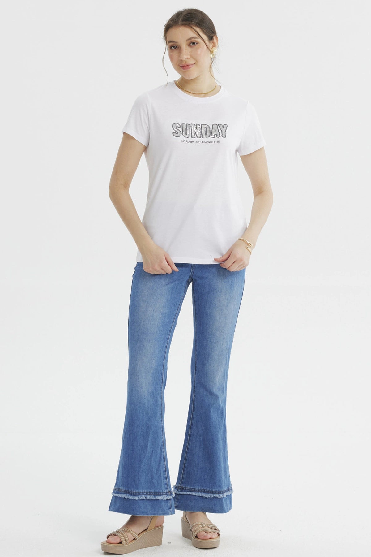 Polera blanca de mujer con texto 'SUNDAY' grande y 'NO ALARM JUST ALMOND LATTE' debajo en el pecho estilo casual