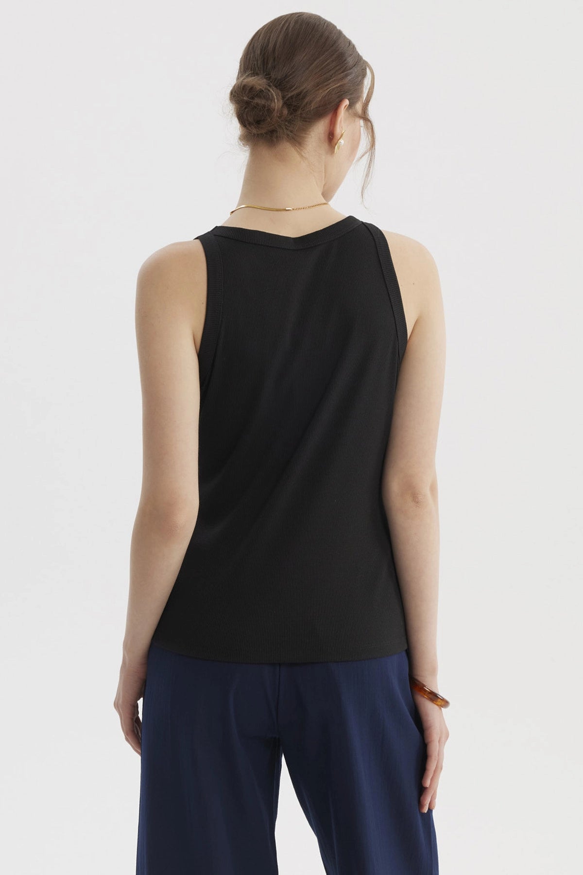 Polera de mujer negra sin mangas con cuello bote diseño rib sin estampa ideal para un look casual y versátil