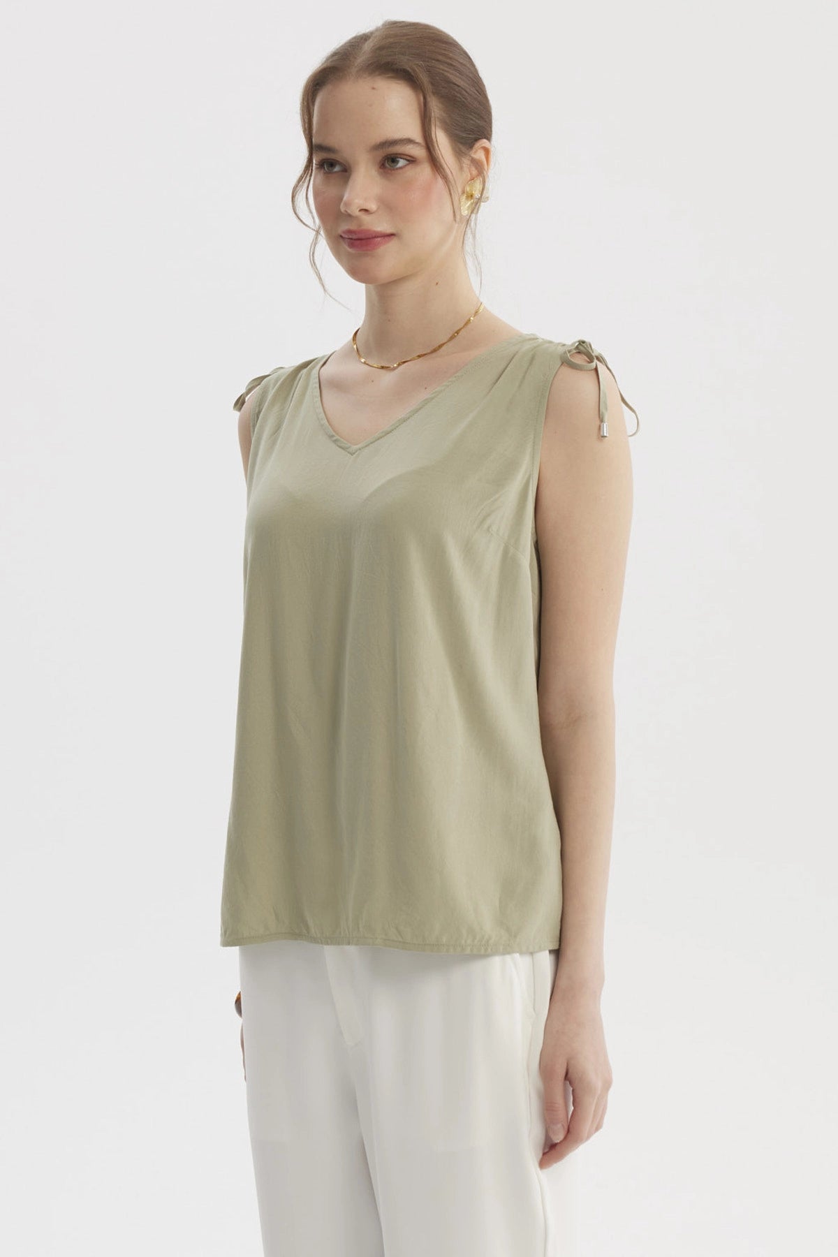 Blusa verde de mujer sin mangas con tiras ajustables en los hombros y diseño liso casual elegante