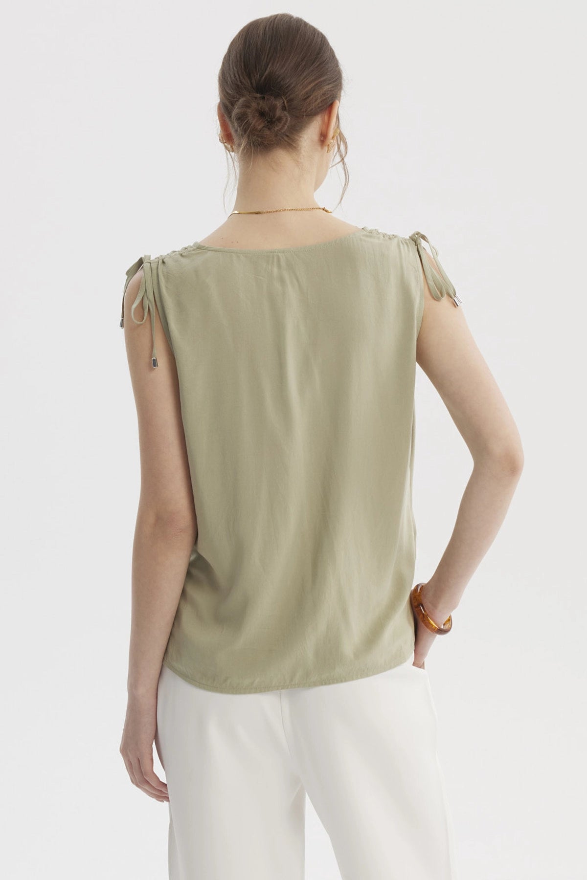 Blusa verde de mujer sin mangas con tiras ajustables en los hombros y diseño liso casual elegante