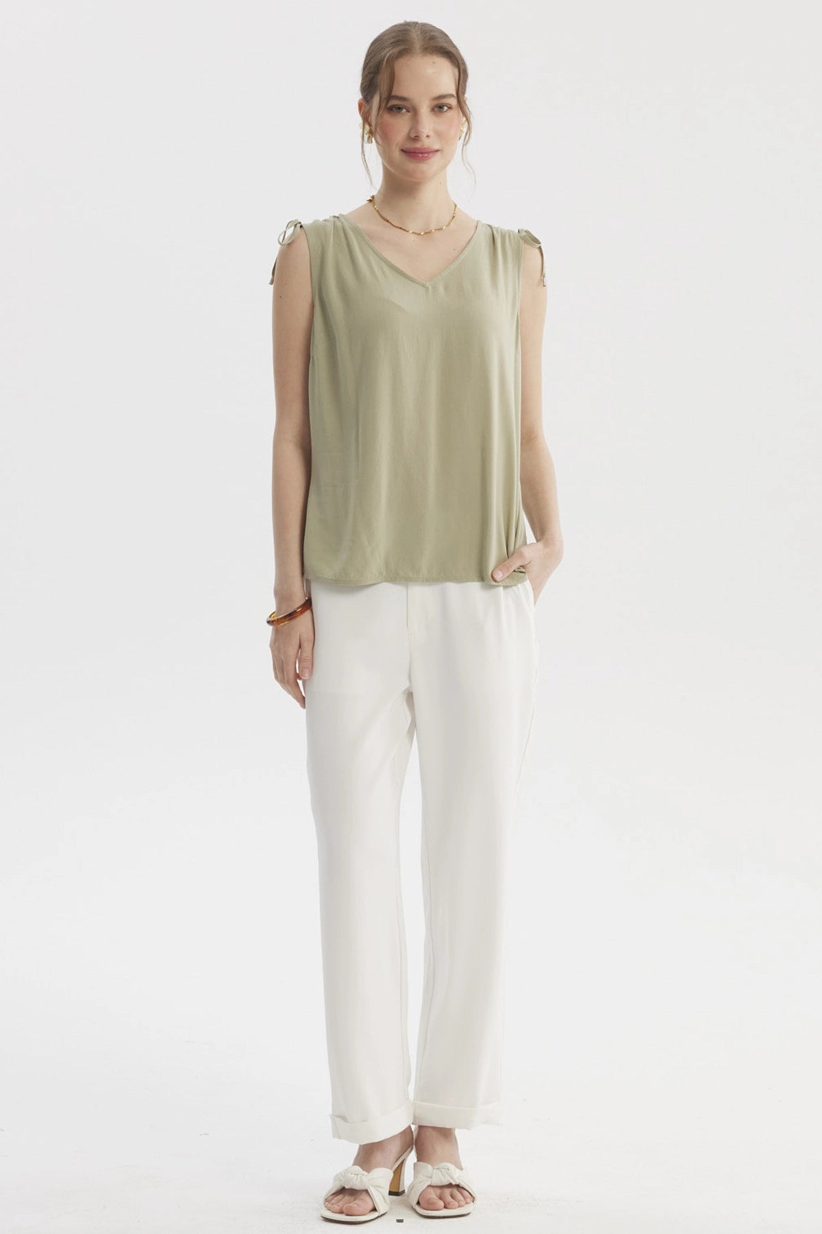 Blusa verde de mujer sin mangas con tiras ajustables en los hombros y diseño liso casual elegante