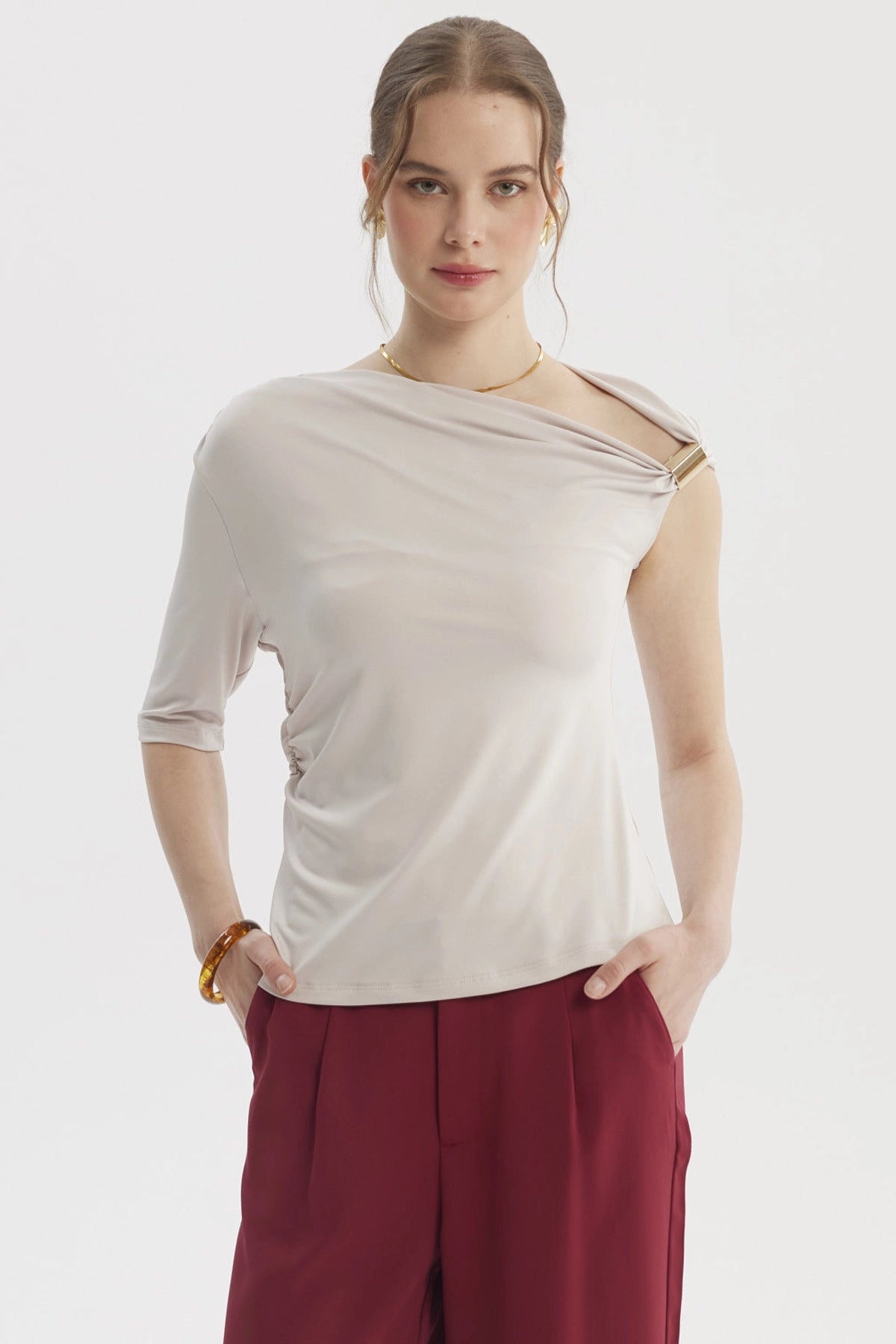 Polera asimétrica arena para mujer con detalle en el hombro y manga corta diseño liso elegante y moderno