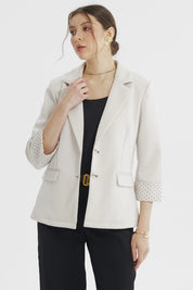 Blazer mujer arena liso con puño estampado de lunares pequeños marrones en el reverso visible elegante y moderno