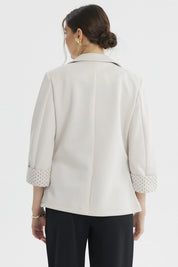 Blazer mujer arena liso con puño estampado de lunares pequeños marrones en el reverso visible elegante y moderno