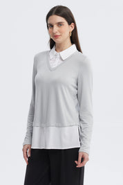 Sweater mujer casual gris con cuello en V manga larga sobre camisa blanca visible en el dobladillo sin estampa