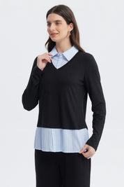 Sweater casual negro de mujer con cuello en V sobre camisa azul con rayas blancas visible en el borde inferior