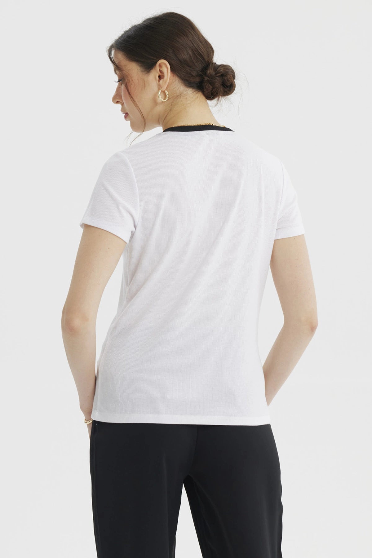 Polera mujer blanca con falso abotonado negro y detalles dorados en el frente sin estampa lisa y elegante