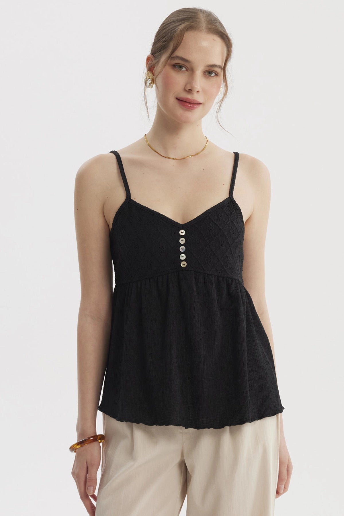 Peto negro de mujer con escote calado y botones decorativos en el frente diseño de tirantes delgados estilo casual