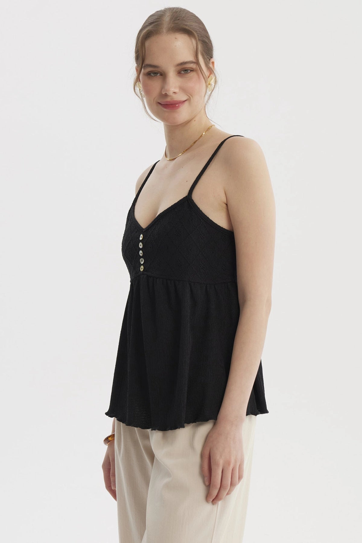Peto negro de mujer con escote calado y botones decorativos en el frente diseño de tirantes delgados estilo casual