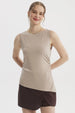 Polera mujer beige claro sin mangas con basta asimétrica diseño liso ajuste en la cintura ideal para un look casual elegante