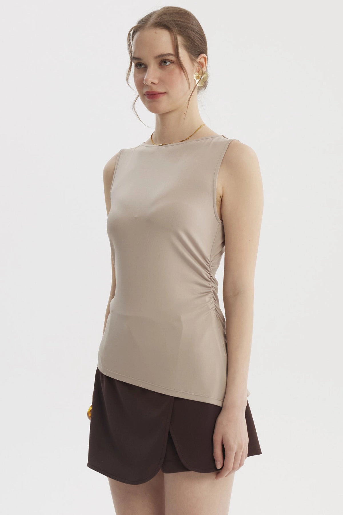 Polera mujer beige claro sin mangas con basta asimétrica diseño liso ajuste en la cintura ideal para un look casual elegante