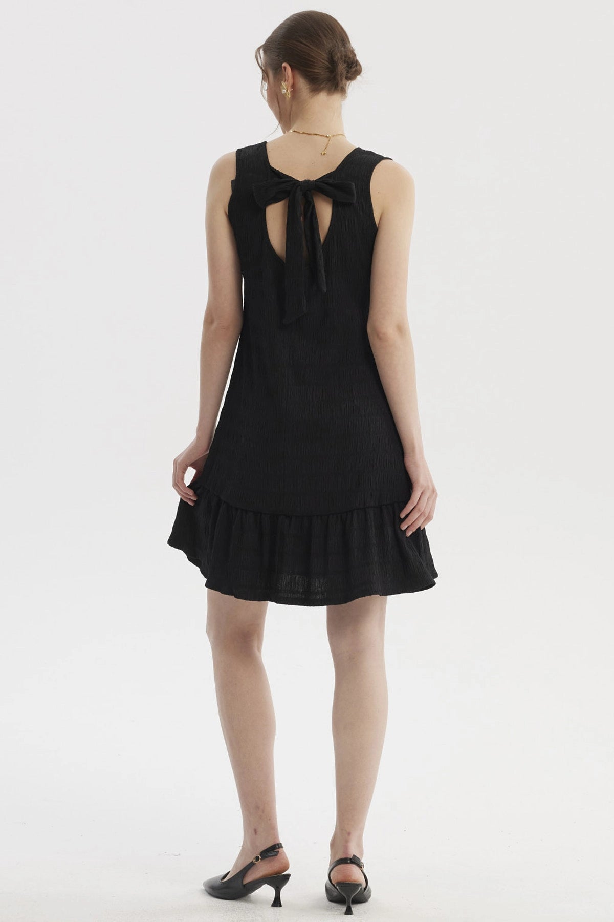 Vestido corto negro texturizado sin mangas con falda con volante diseño liso ideal para ocasiones casuales