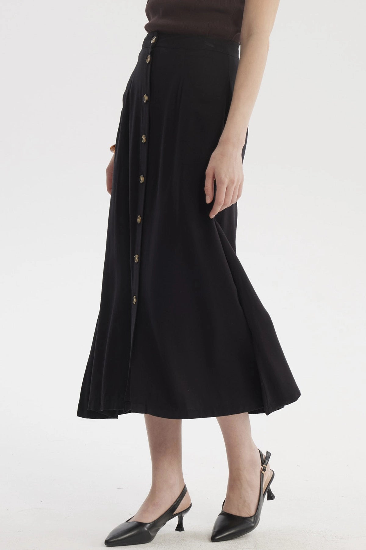 Falda midi negra con botones frontales dorados prenda lisa elegante para un look casual y sofisticado