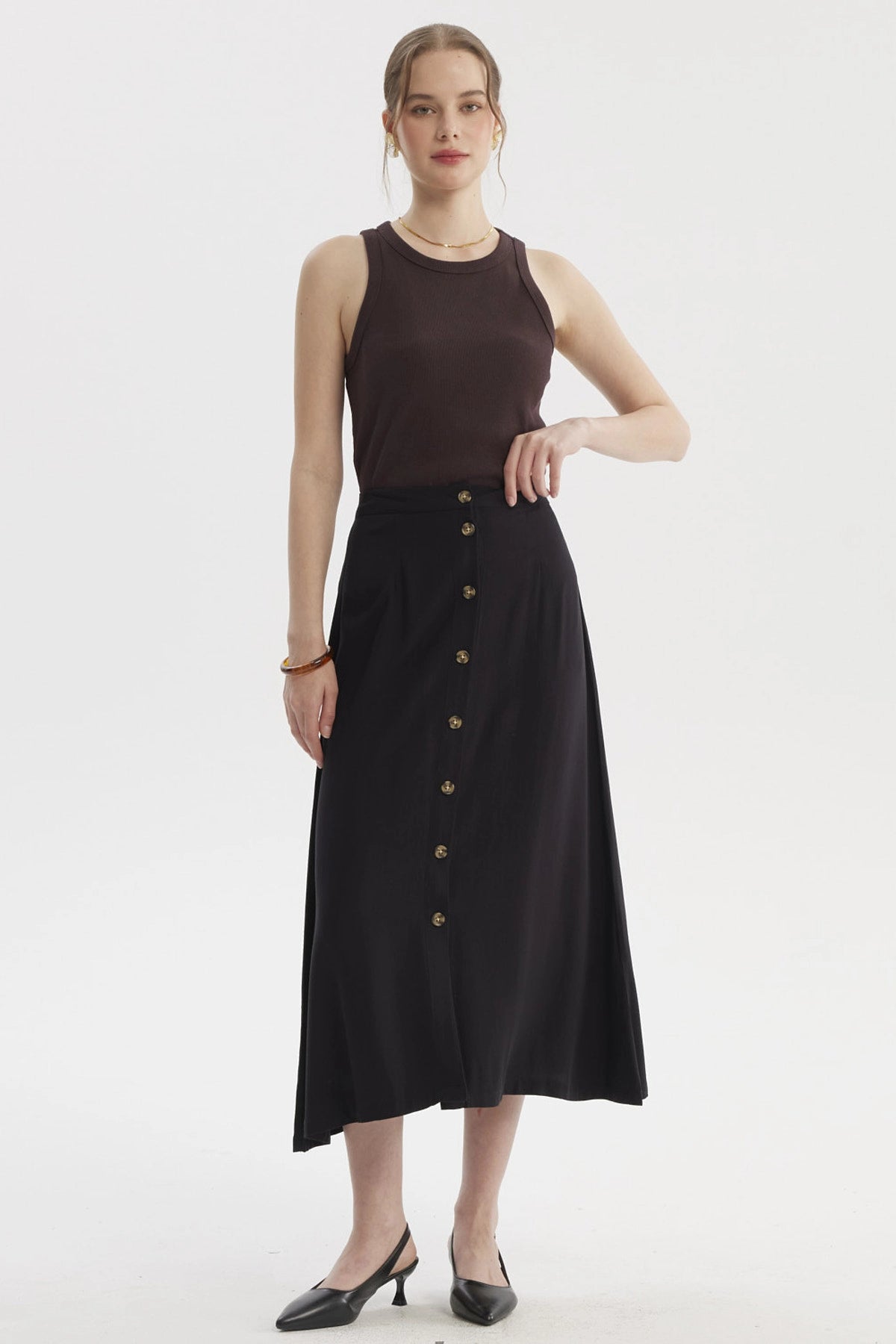 Falda midi negra con botones frontales dorados prenda lisa elegante para un look casual y sofisticado