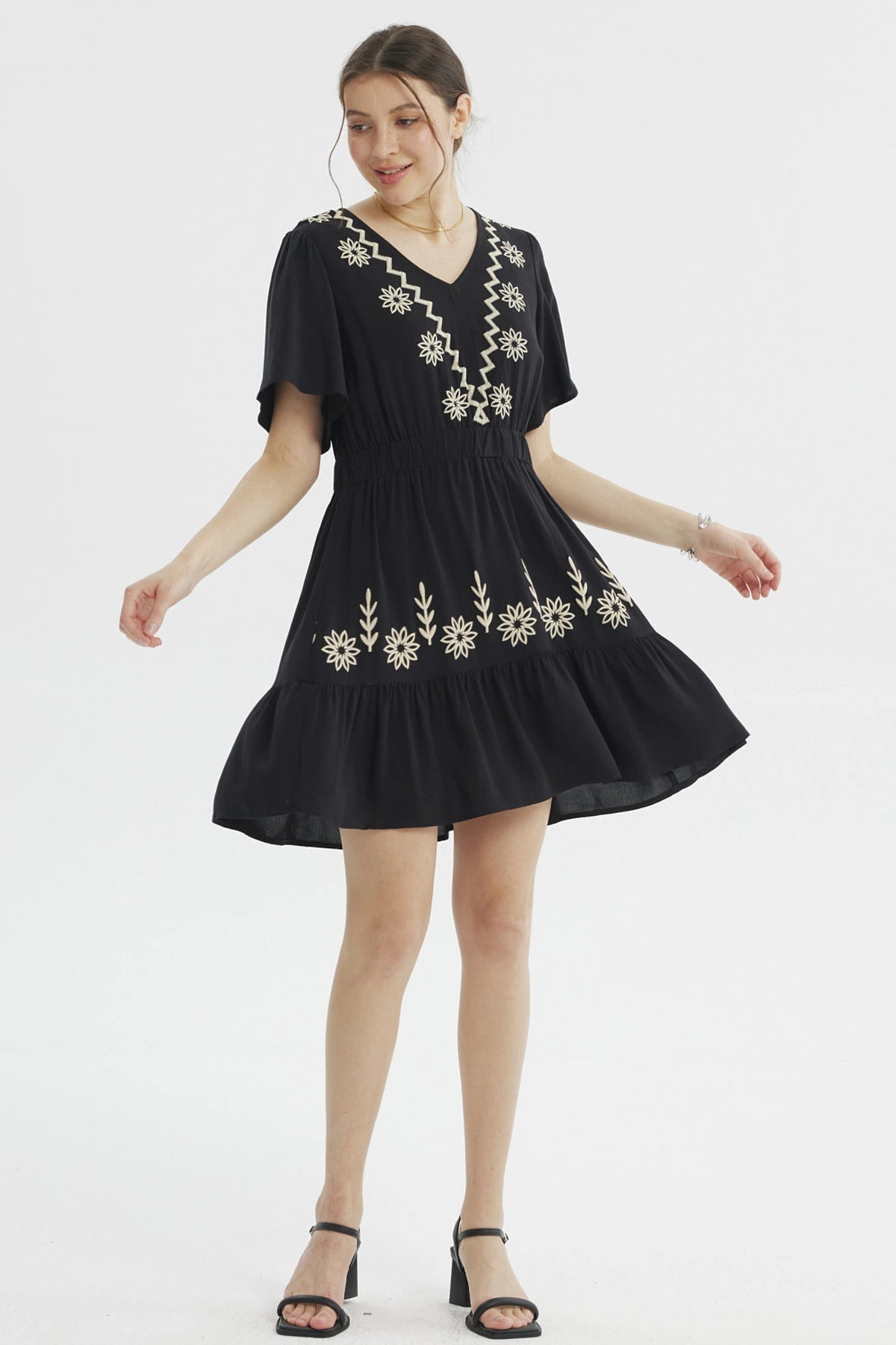 Vestido negro de mujer con bordados florales beige en el escote y la falda diseño relajado sin estampas adicionales
