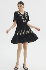 Vestido negro de mujer con bordados florales beige en el escote y la falda diseño relajado sin estampas adicionales