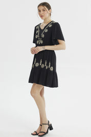 Vestido negro de mujer con bordados florales beige en el escote y la falda diseño relajado sin estampas adicionales