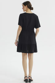 Vestido negro de mujer con bordados florales beige en el escote y la falda diseño relajado sin estampas adicionales