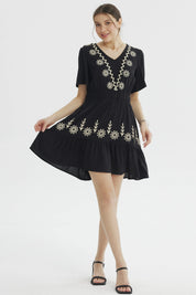 Vestido negro de mujer con bordados florales beige en el escote y la falda diseño relajado sin estampas adicionales