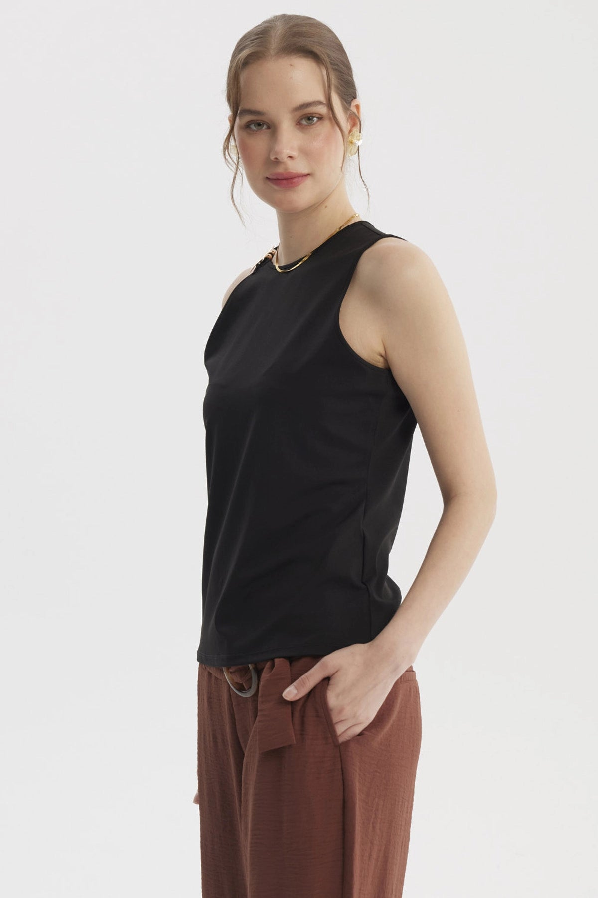 Peto negro para mujer con aplicación metálica en el hombro izquierdo estilo elegante y moderno sin estampas