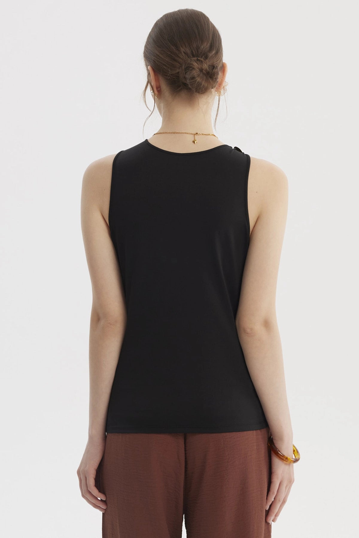 Peto negro para mujer con aplicación metálica en el hombro izquierdo estilo elegante y moderno sin estampas