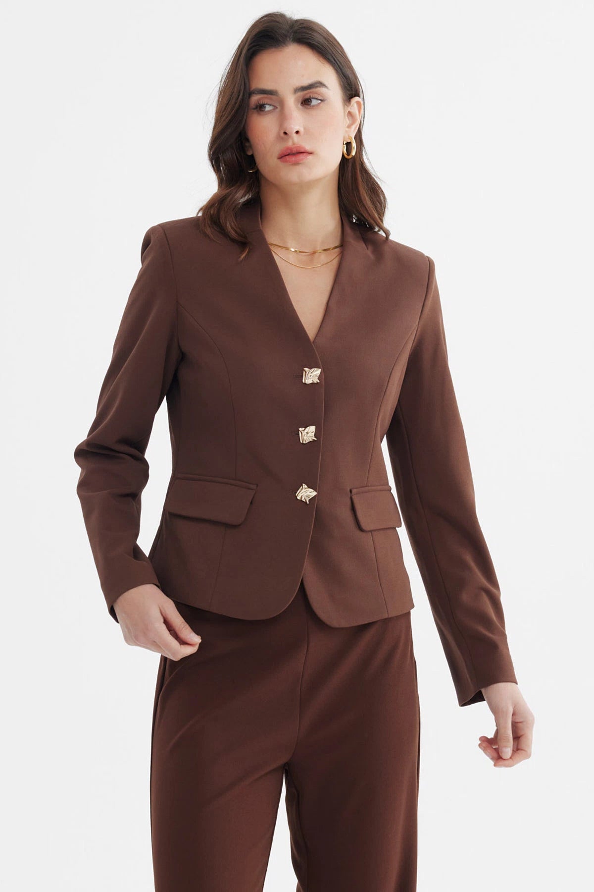 Blazer abotonado mujer color chocolate con bolsillos frontales y botones decorativos dorados sin estampa visible