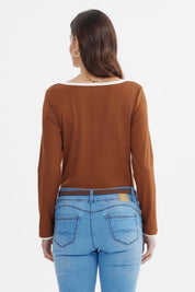Polera ajustada café con cuello V y ribete blanco sin estampado visible elegante y moderna