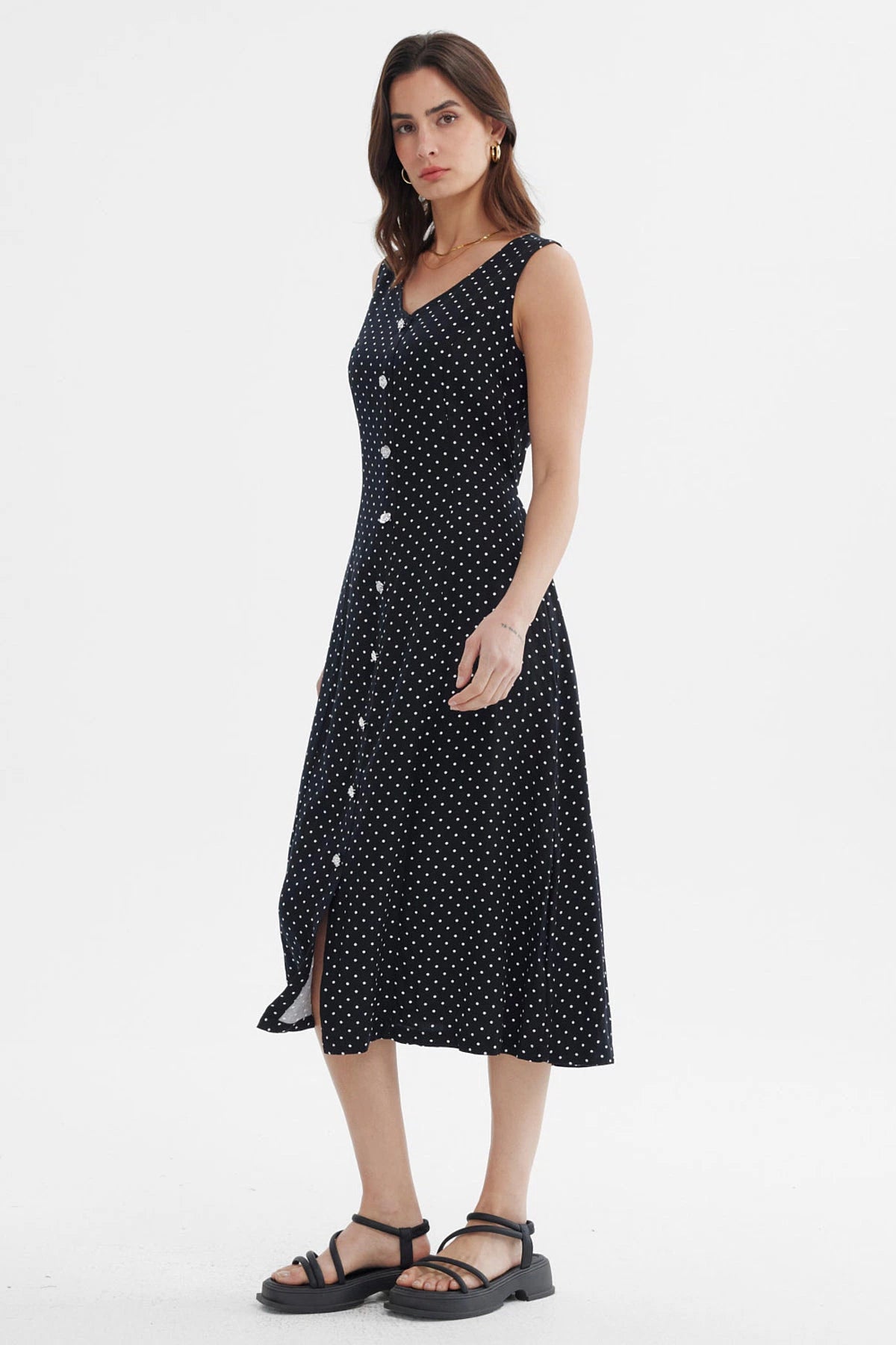 Vestido negro sin mangas con botones blancos al frente y diseño de lunares pequeños blancos