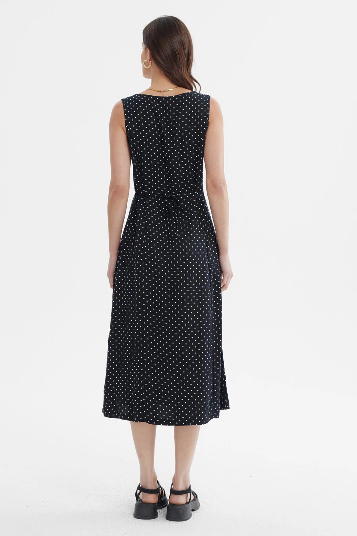 Vestido negro sin mangas con botones blancos al frente y diseño de lunares pequeños blancos
