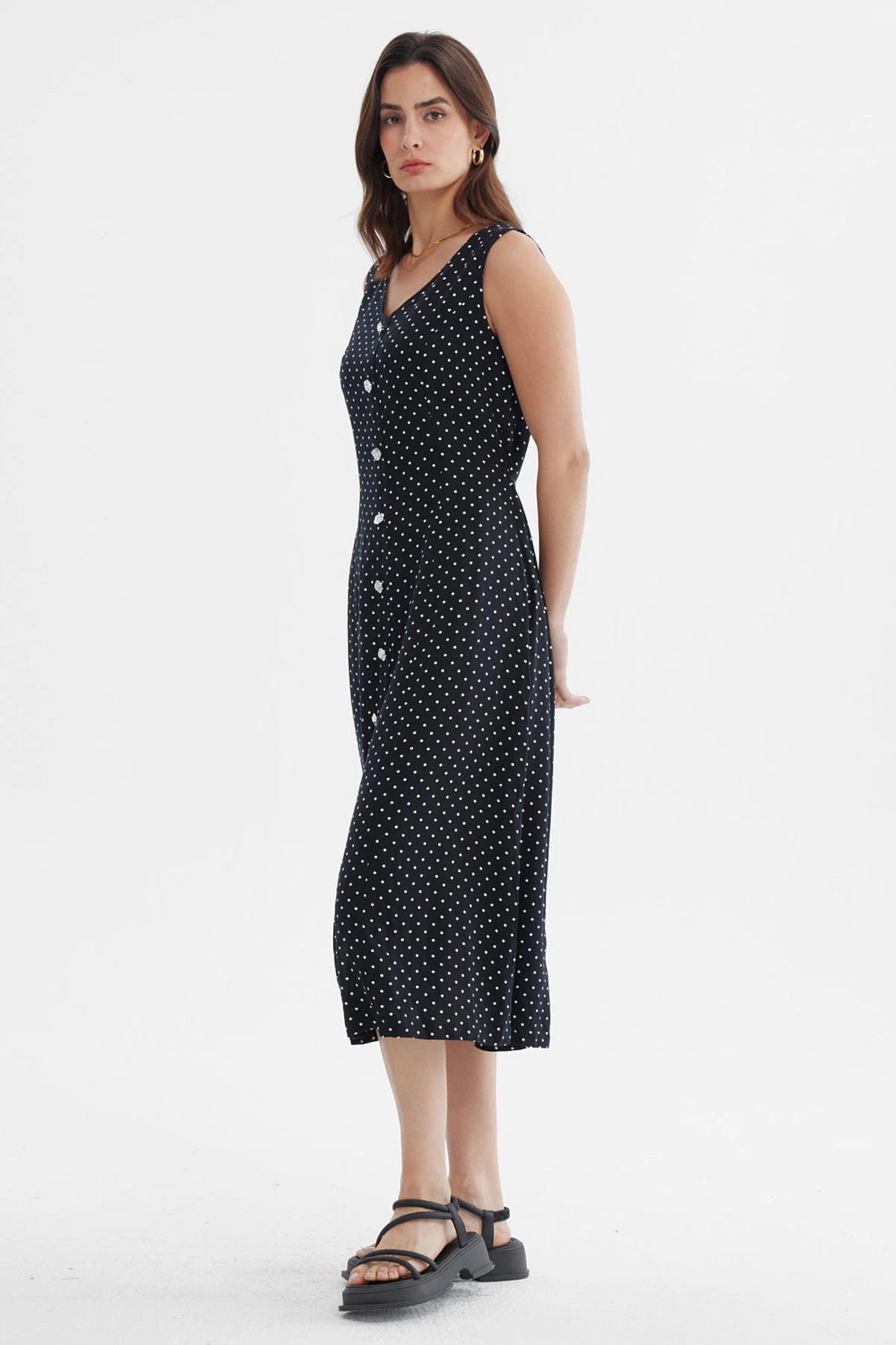 Vestido negro sin mangas con botones blancos al frente y diseño de lunares pequeños blancos