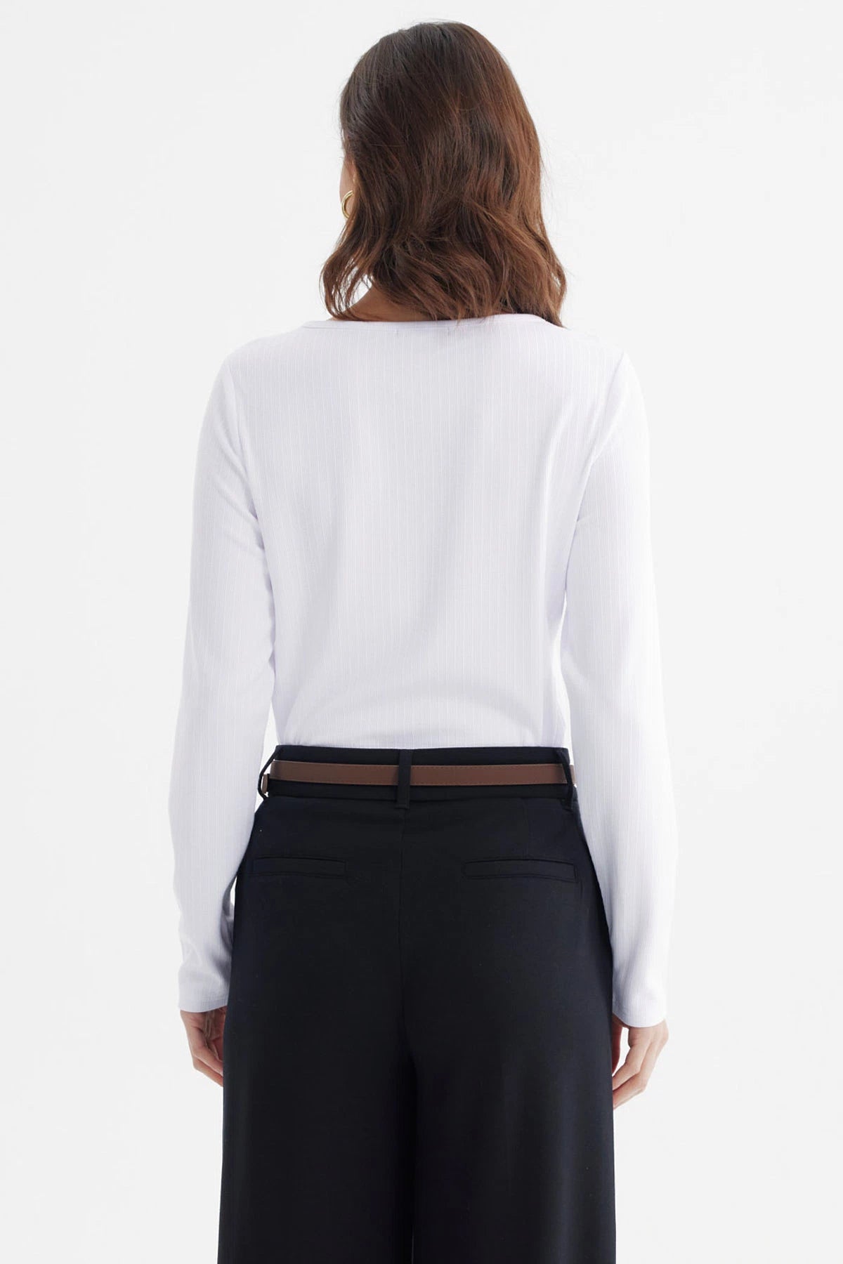 Polera ajustada blanca de manga larga con detalle de abertura y broche dorado en el escote sin estampa lisa