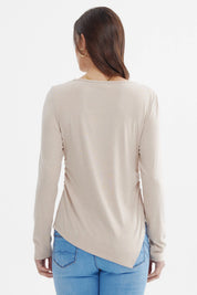 Polera mujer ajustada beige lisa sin estampa de manga larga ajuste sutil a los lados y corte asimétrico en el dobladillo