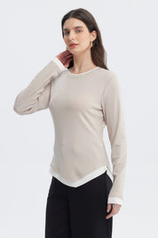 Polera beige de manga larga con bordes blancos en cuello y puños diseño liso ajuste relajado
