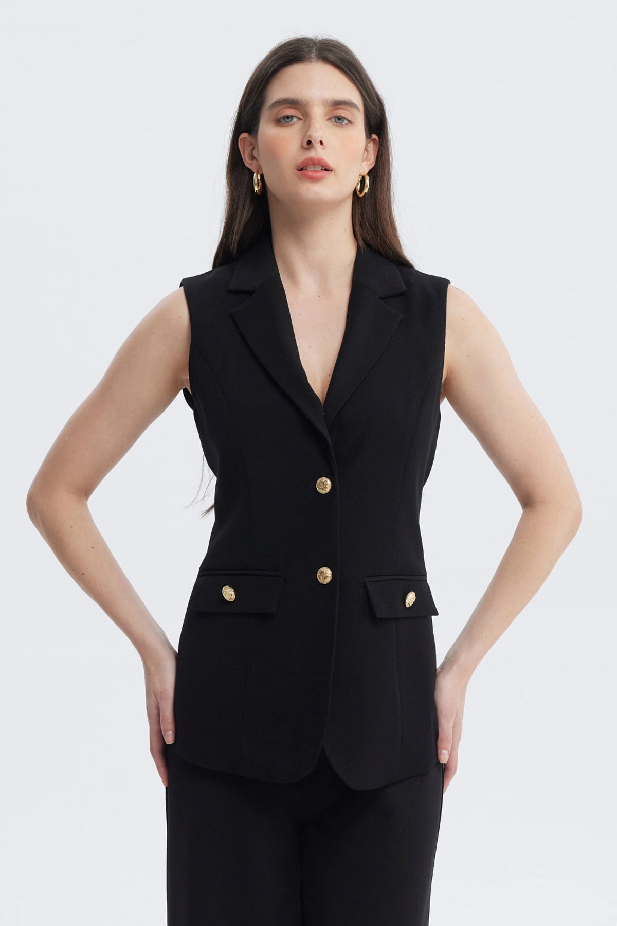 Blazer largo negro sin mangas para mujer con botones dorados en el frente y bolsillos con solapa lisa elegante