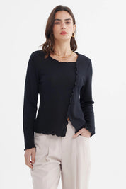 Polera negra mujer con basta asimétrica detalle ondulado en borde sin estampa diseño liso elegante