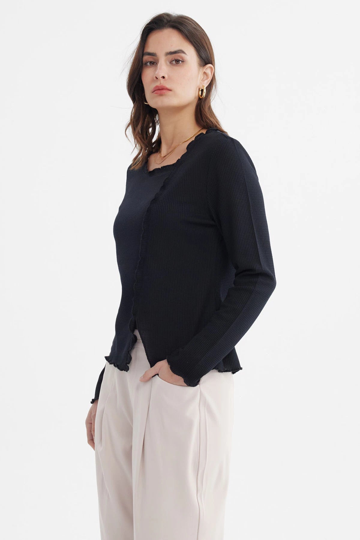Polera negra mujer con basta asimétrica detalle ondulado en borde sin estampa diseño liso elegante