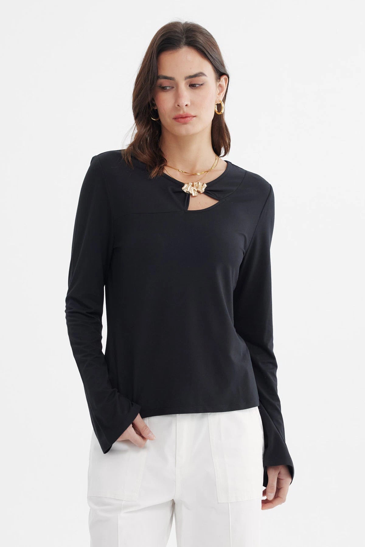 Polera negra de mujer con aplicación metálica en el pecho lisa de manga larga y escote redondo elegante y sobria