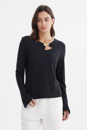 Polera negra de mujer con aplicación metálica en el pecho lisa de manga larga y escote redondo elegante y sobria