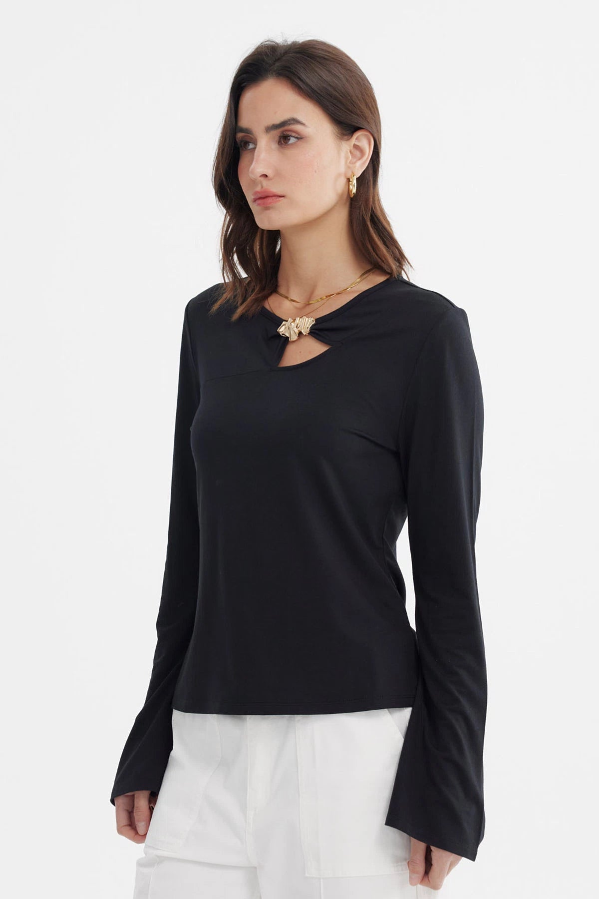 Polera negra de mujer con aplicación metálica en el pecho lisa de manga larga y escote redondo elegante y sobria