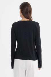 Polera negra de mujer con aplicación metálica en el pecho lisa de manga larga y escote redondo elegante y sobria