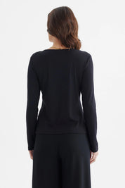 Polera negra de mujer con manga larga abertura en el hombro derecho y nudo estilizado diseño liso elegante