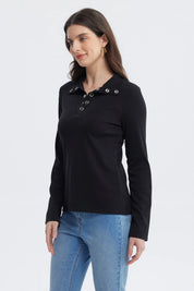 Polera negra de mujer con botones plateados en el cuello y manga larga diseño liso