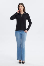 Polera negra de mujer con botones plateados en el cuello y manga larga diseño liso