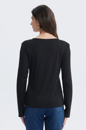 Polera negra mujer con botones metálicos al frente y bolsillos en el pecho diseño sencillo y elegante