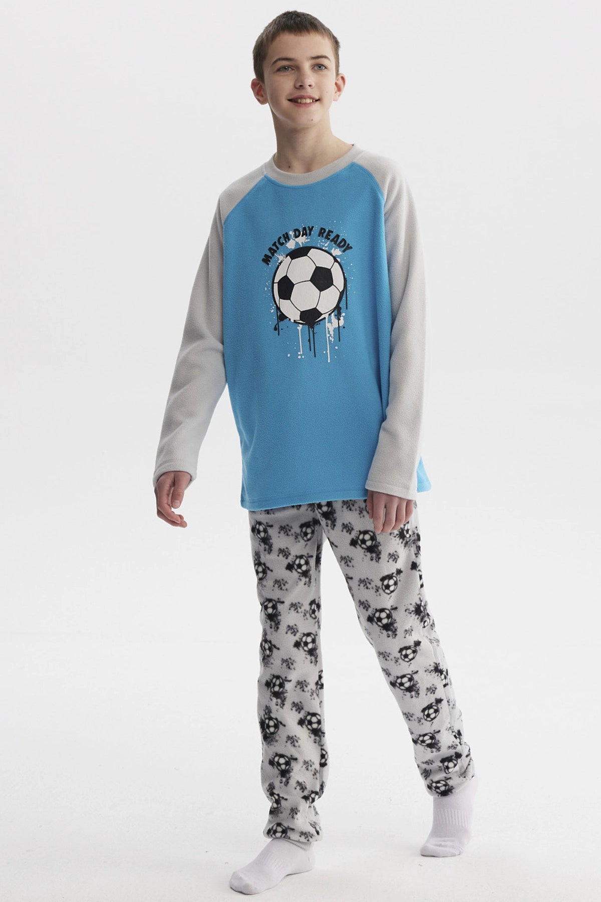 Pijama de niño gris con polera azul estampada con balón de fútbol en el centro y pantalón con balones en patrón repetido