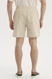 Short de baño hombre liso beige con cordón blanco visible en la cintura diseño sencillo sin estampas
