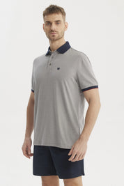 Polera gris de hombre con cuello contraste azul oscuro lisa y detalle de logo pequeño en el pecho estilo casual