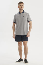 Polera gris de hombre con cuello contraste azul oscuro lisa y detalle de logo pequeño en el pecho estilo casual