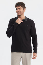 Polera negra de hombre con cuello contraste gris manga larga y logo pequeño bordado en el pecho lado izquierdo lisa