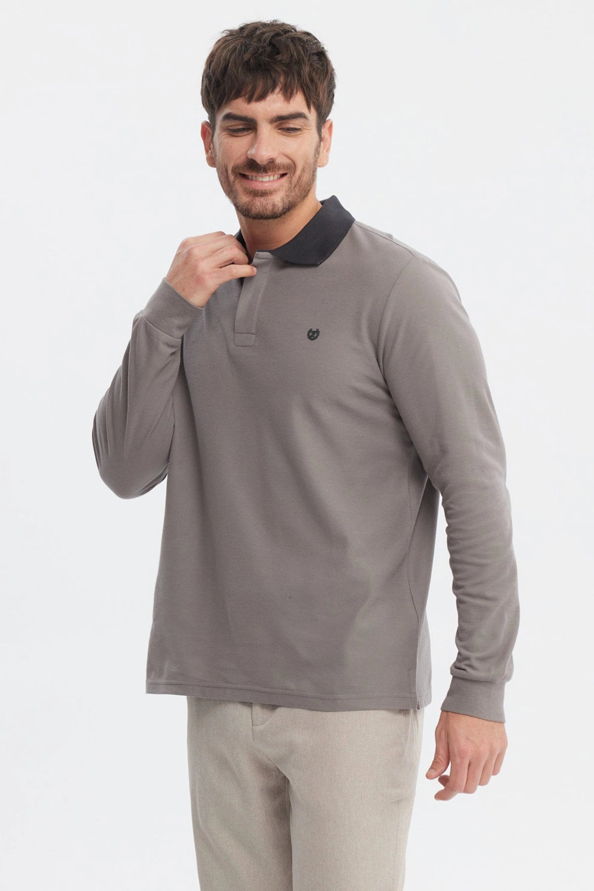 Polera gris de hombre con cuello contraste negro manga larga lisa ajuste relajado y logo pequeño en el pecho